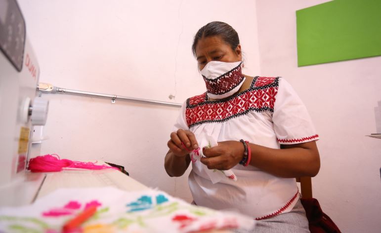 Mujeres otomíes elaboran cubrebocas bordados a mano