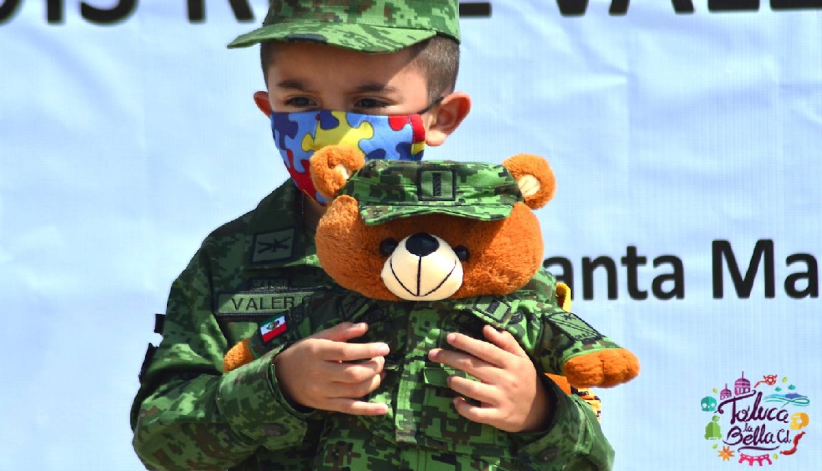 niño de cinco años con autismo se viste de soldado mientras abraza a su osito uniformado despues de cumplir su sueño de convertirse en soldado