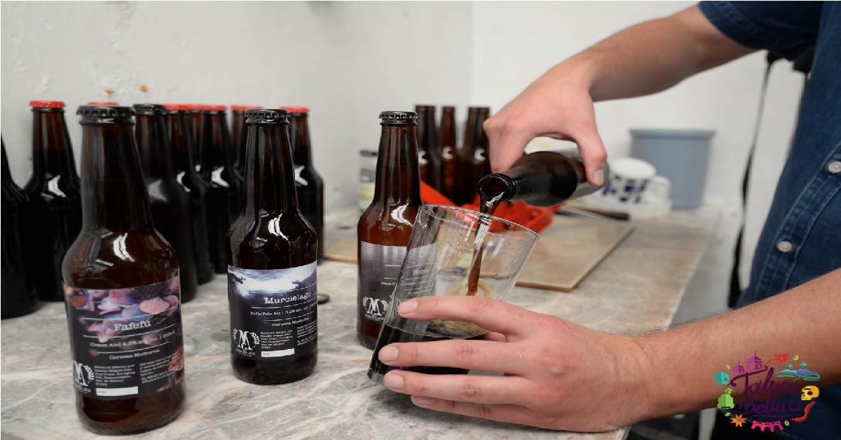 CERVEZA ARTESANAL SOBRE MESA Y JOVEN SIRVIENDO UNA EN UN VASO