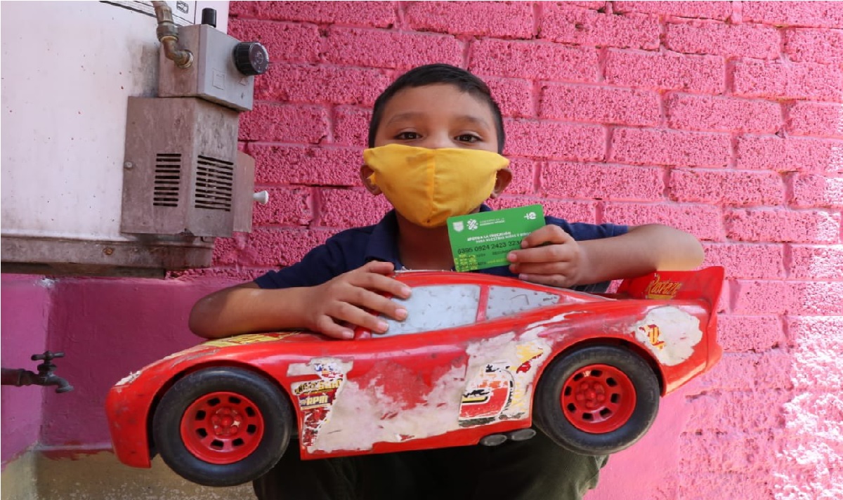niño con auto de juguete recibiendo su tarjeta de mi beca para empezar
