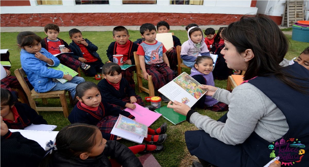 Maestra leyendo un cuento a niños y niñas de preescolar en jardín de niños edomex