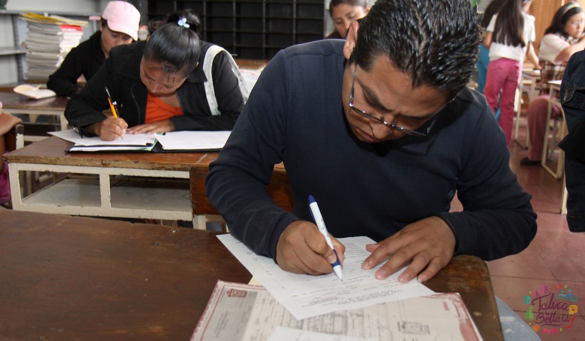 Padre de familia firmando la boleta de su hijo