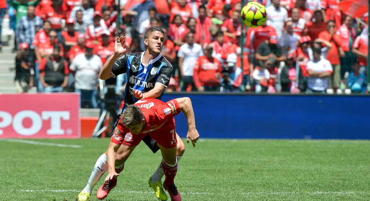 jugador de toluca fc disputa balón en ocntra de jugador del querétaro