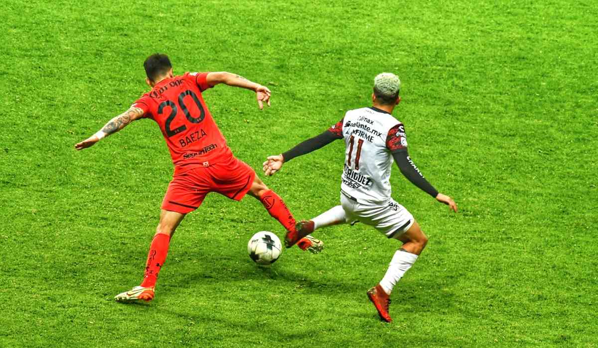 Disputa del balón entre Baeza y Rodriguez jugadores de Toluca FC y Xolos respectivamente