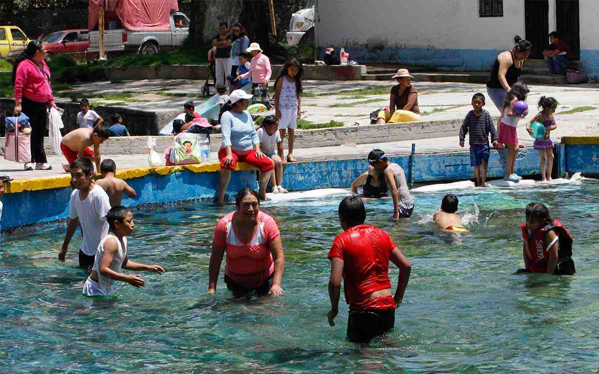 niños y padres en alberca disfrutando vacaciones de semana santa 2022 sep