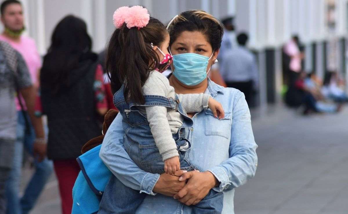 Madre soltera caminando por la calle con su hija puede solicitar apoyo económico de mil 600 pesos de la Beca Bienestar