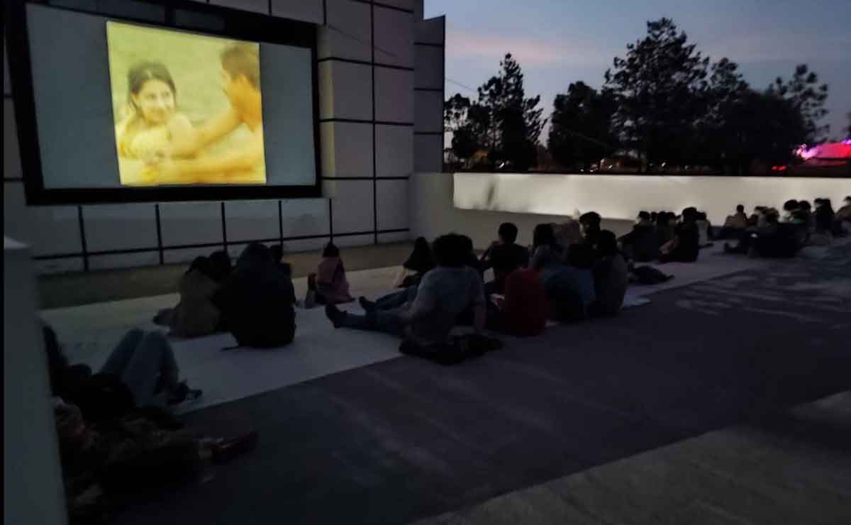 Gente disfrutando de la temporada cine de temperatura al aire libre