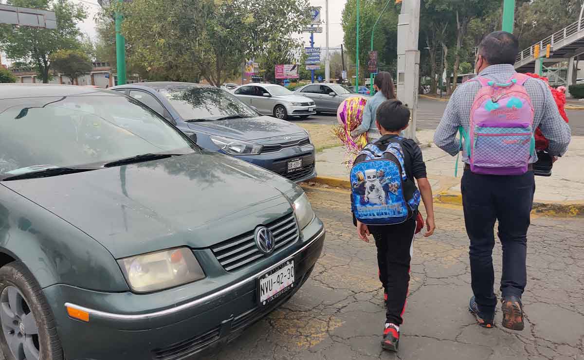 Papás saliendo de la escuela de su hijo para las vacaciones de verano 2022
