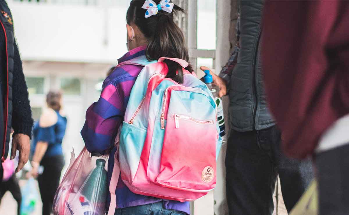 Niña yendo a la escuela para ir por su boleta de calificaciones