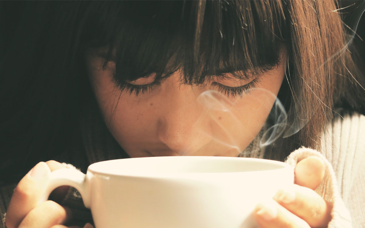 chica oliendo taza en festival de cafe