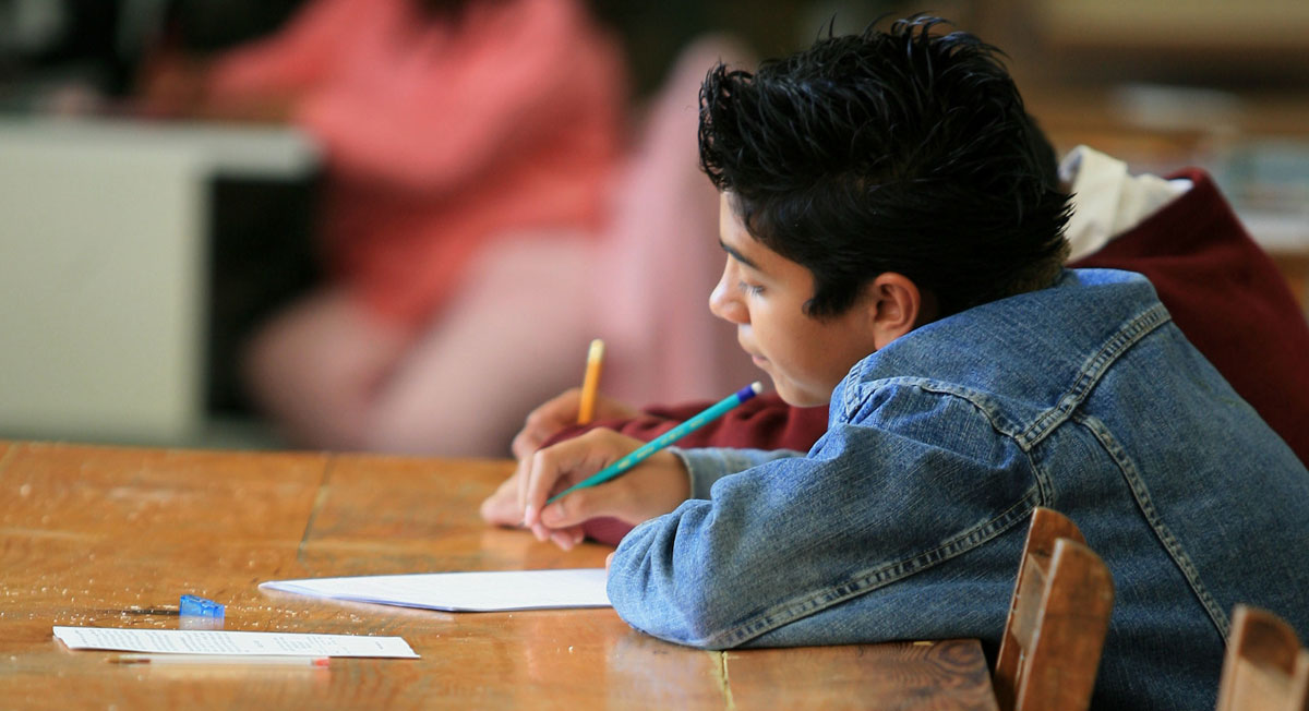 Niño escribe con útiles gratis de la sep en ciclo escolar 2022 2023