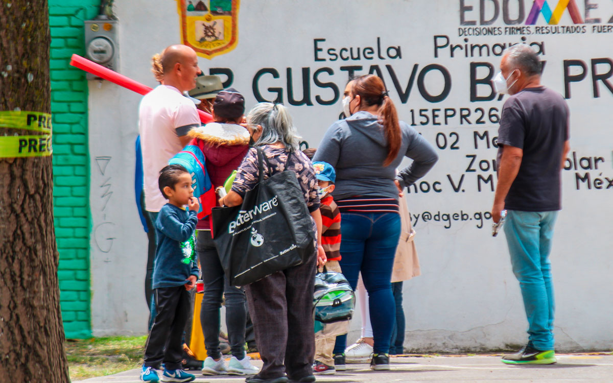 personas afuera de escuela publica de educacion basica