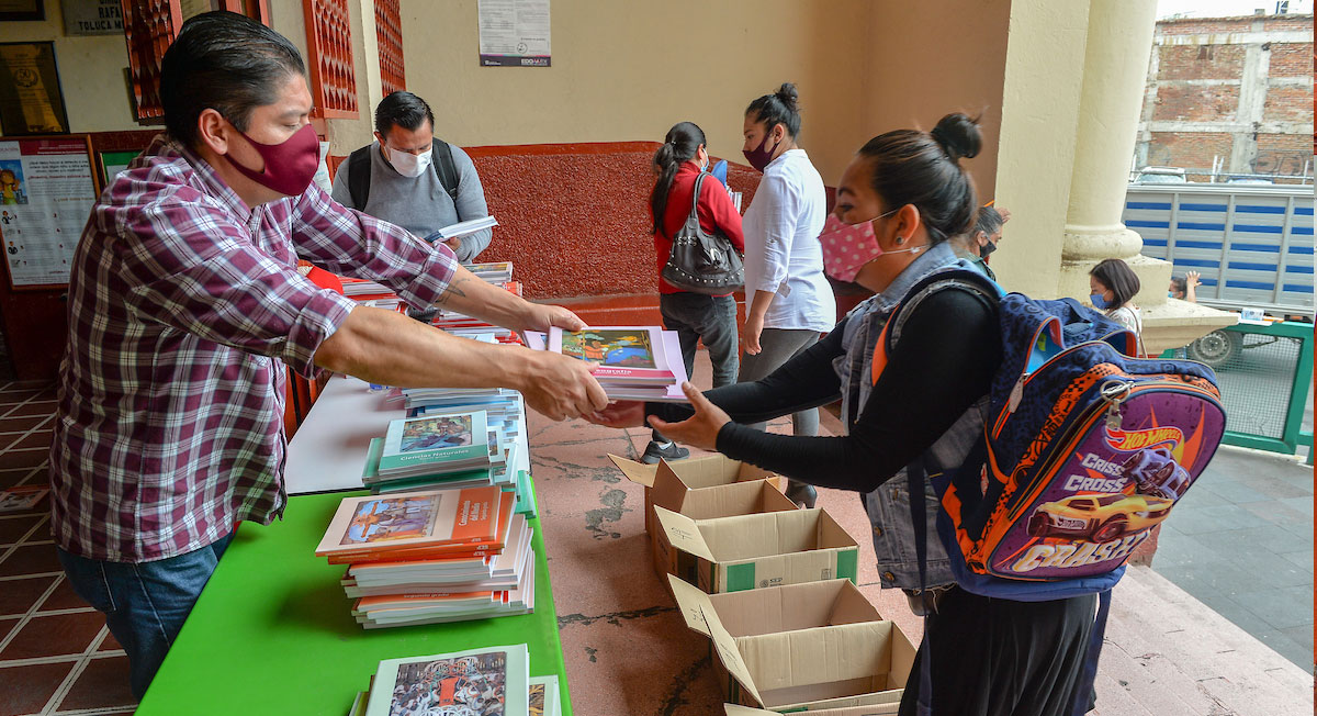 maestro entrega libros de texto gratuito a madre de familia en ciclo escolar 2022-2023