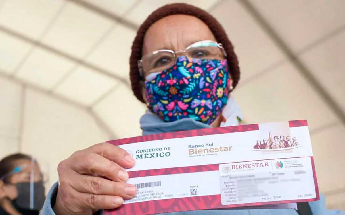 mujer mayor recibiendo tarjeta d epago pendion bienestar adultos mayores 2022