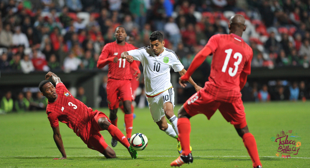 tecatito corona disputando un balon durante un partido de la selección mexicana contra Panamá