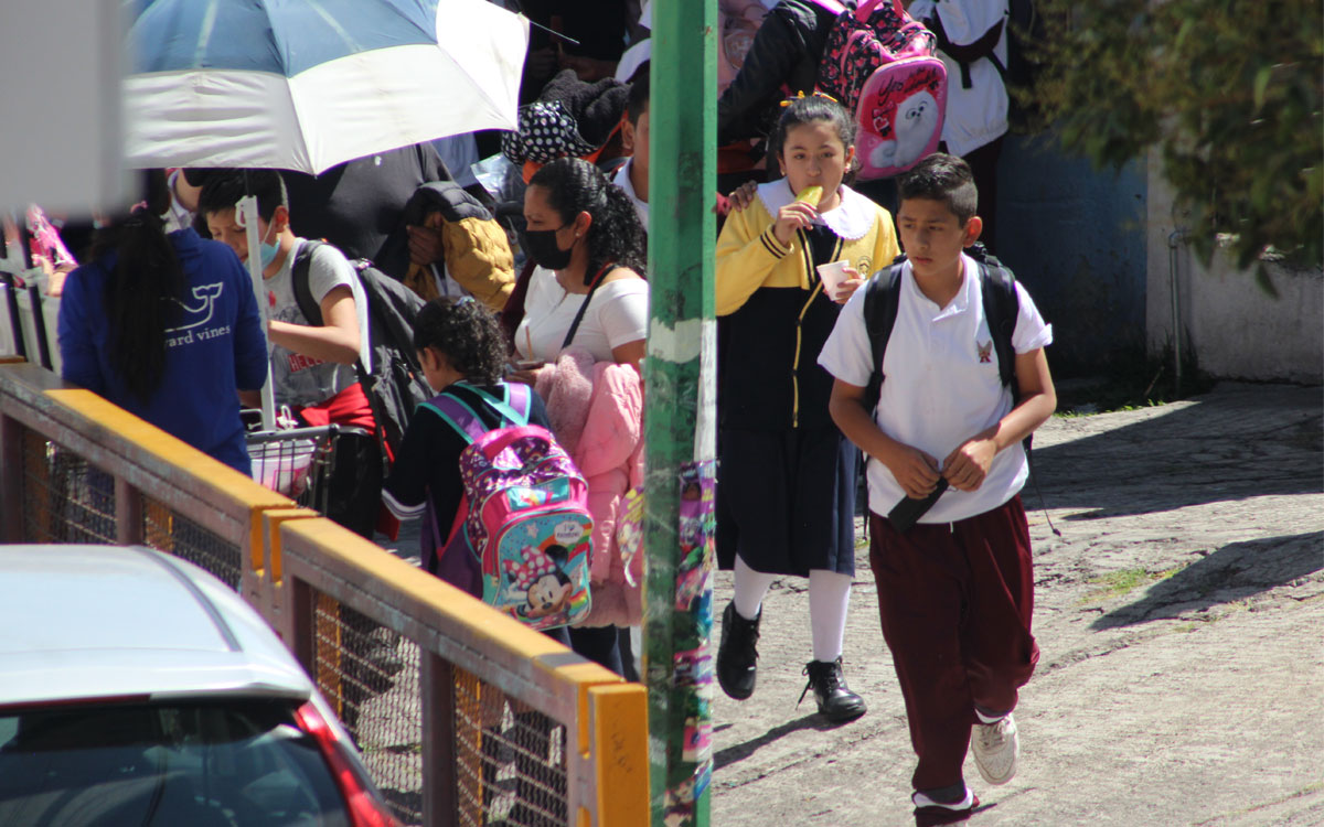 niños saliendo de la escuela por puente escolar