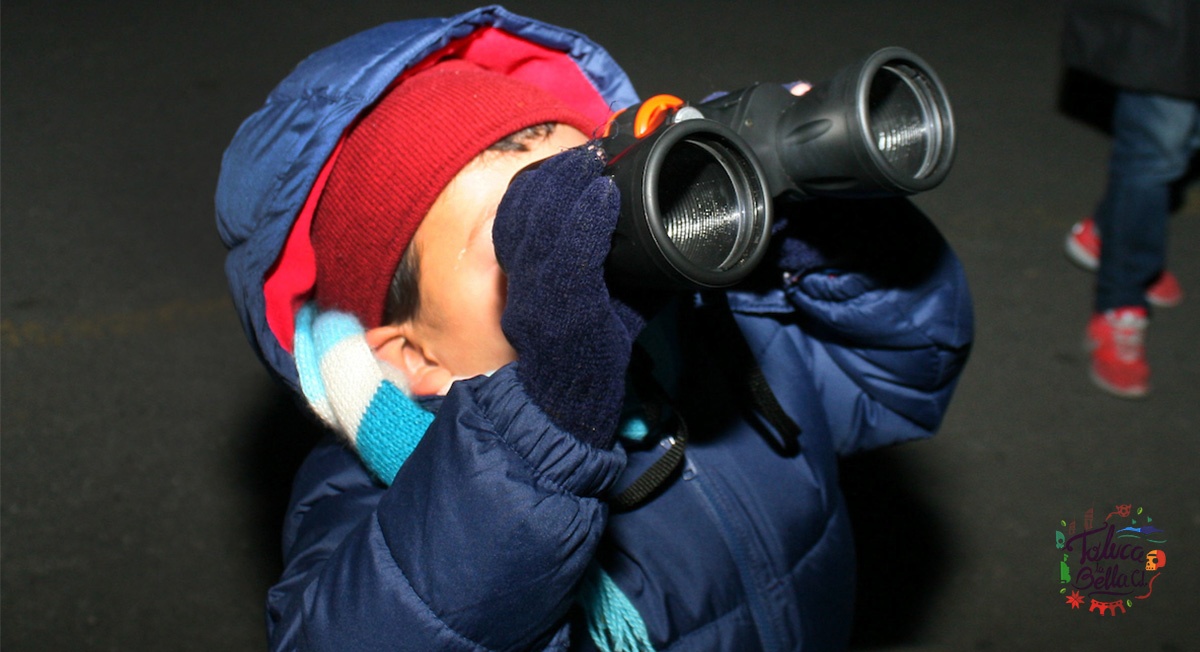 Niño con binoculares viendo la lluvia de estrellas