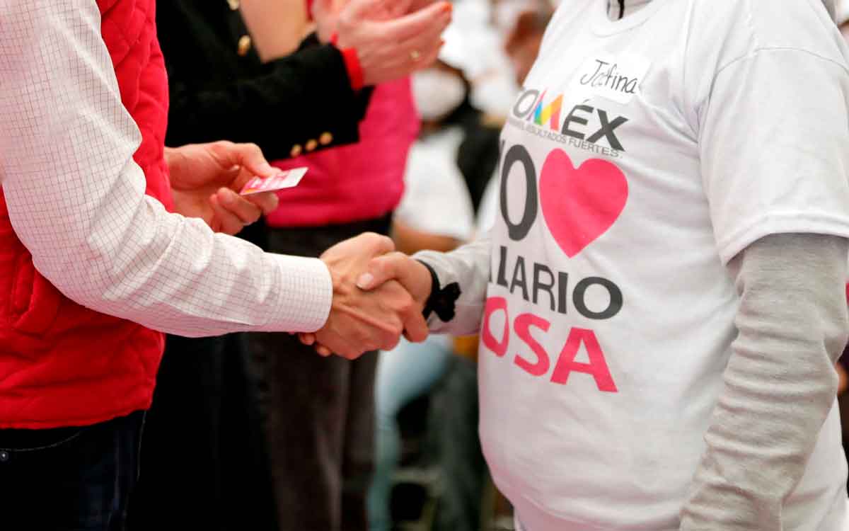 entregando tarjeta rosa a mujer beneficiada de salario rosa 2023