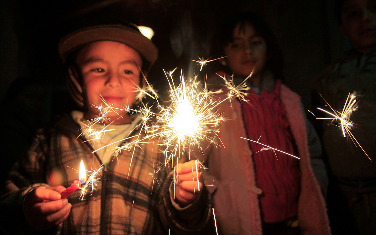 niño con luz de bengala en posada navideña