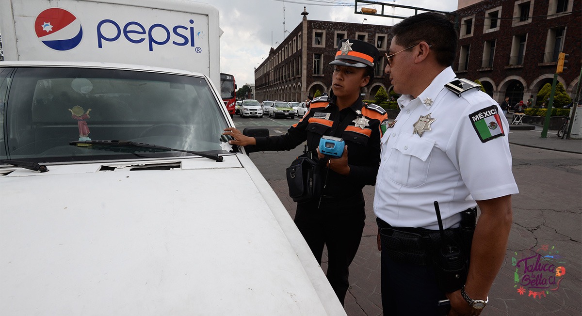 Policías de tránsito multando a conductor por manejar con placas vencidas