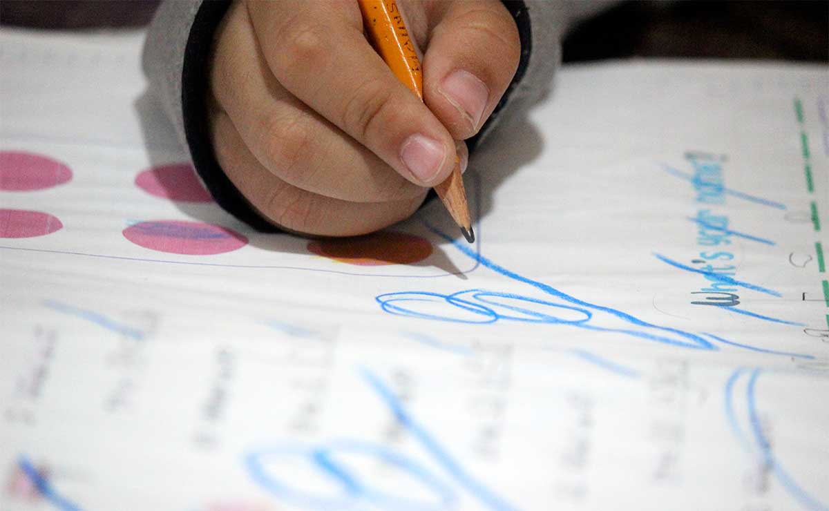 Niño saliendo de vacaciones de verano tras recibir su boleta de calificacion de la SEP