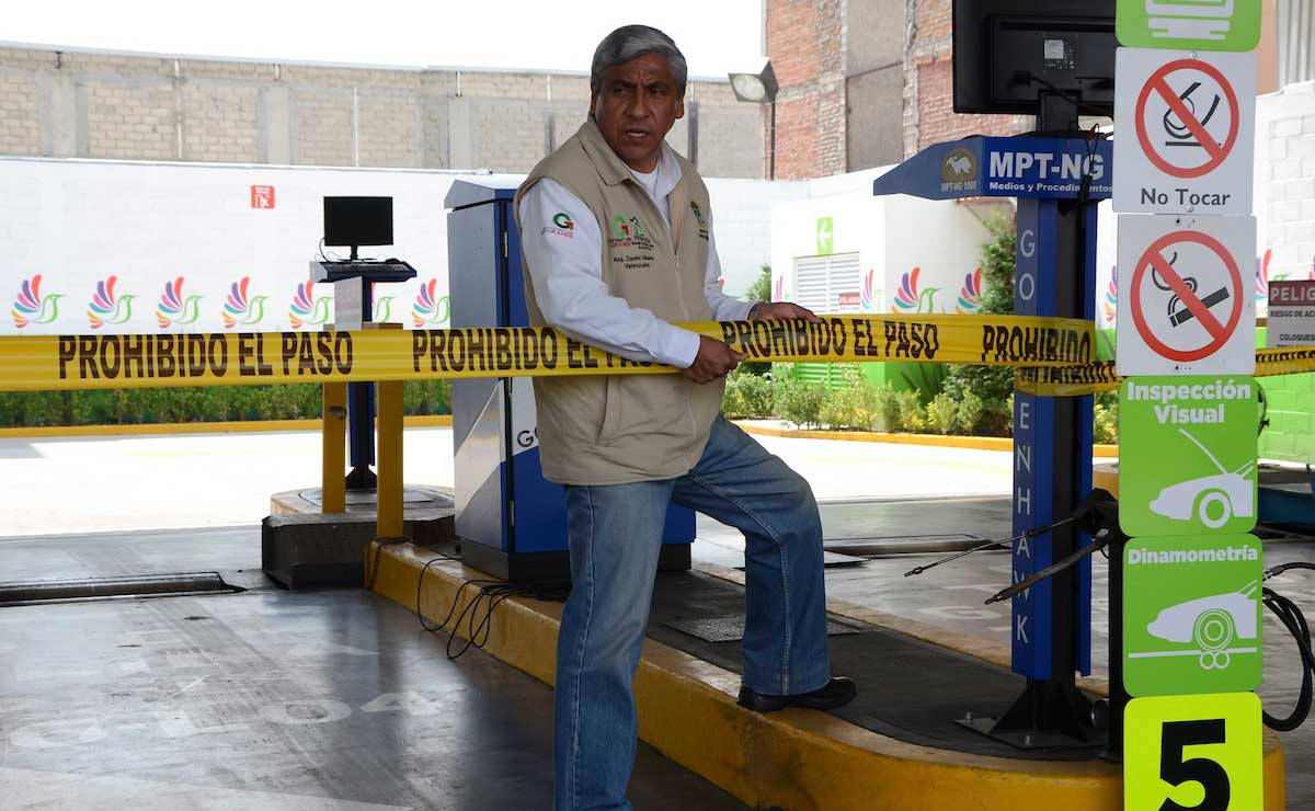 Trabajador de Verificentros poniendo un letrero