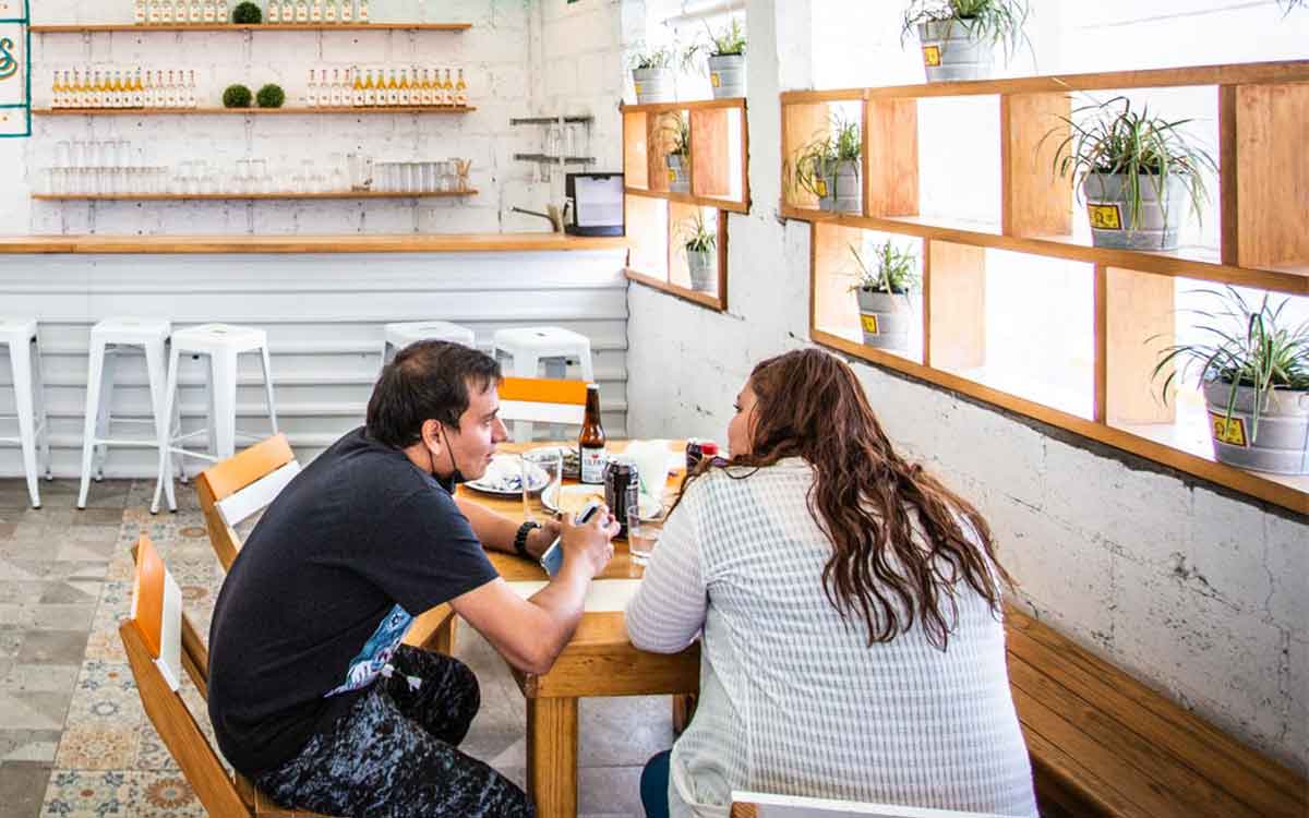 Pareja en un restaurante degustando de su comida y platicando